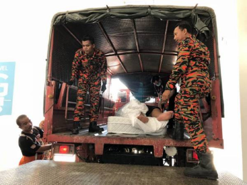 华裔男子被抬上卡车送往医院。(马来西亚《中国报》) 华裔男子被抬上卡车送往医院。(马来西亚《中国报》)