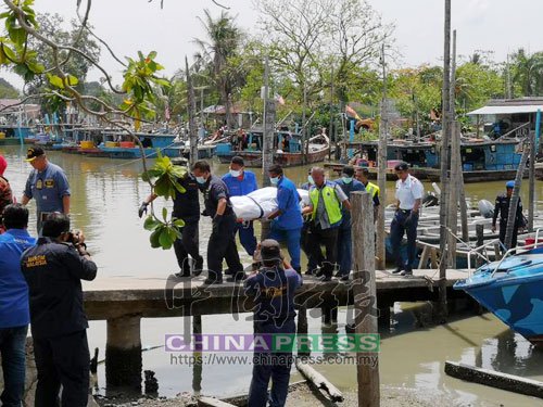  救援人员将打捞到的遇难人员遗体抬上岸。 (马来西亚中国报 蔡纬杨 摄)