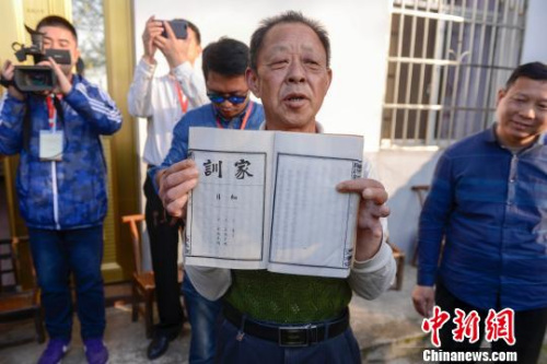 金桥村村民罗仲璜向海外华文媒体一行展示罗氏家训。 杨华峰 摄 金桥村村民罗仲璜向海外华文媒体一行展示罗氏家训。 杨华峰 摄