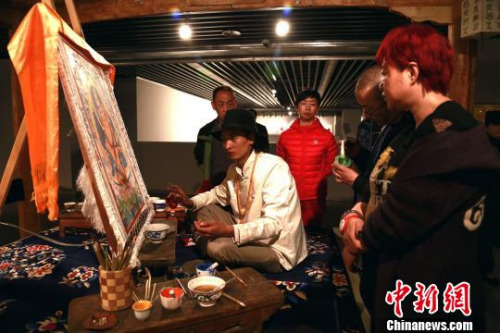 3月29日，青海省美术馆正在展出“中国非物质文化遗产传承人群研修研习培训计划”青海地区的丰硕成果，图为多杰加正在给参观的人群讲解唐卡绘制。　马铭言 摄