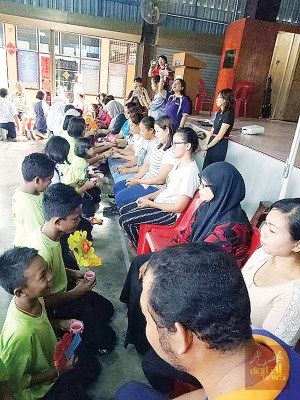 公益华小的各族学生，跪下捧茶给养育他们长大的长辈们。（马来西亚《光华日报》）