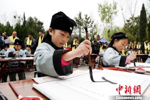 孔子故里的学童们在夫子洞广场参加戊戌年学童启蒙开笔礼,学写“人”字。 沙见龙 摄 孔子故里的学童们在夫子洞广场参加戊戌年学童启蒙开笔礼,学写“人”字。 沙见龙 摄