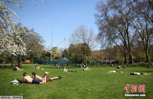 伦敦马拉松官方也建议普通选手在这样的高温天气下，暂时放弃冲击个人纪录的想法，跑的更慢一点，以保证安全。图为伦敦民众在圣詹姆斯公园的草地上享受日光浴。