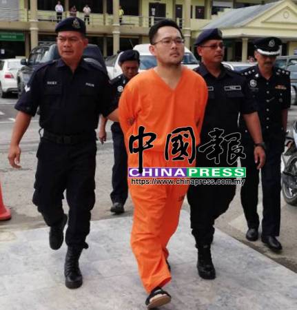 涉嫌将中国妻子分尸的嫌凶黄敬浩(中)被警方押上法庭过堂(马来西亚《中国报》)