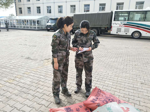 两名女士官正在清点核对海运物资