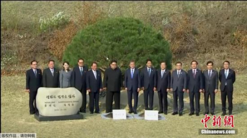 当地时间4月27日,金正恩与文在寅在板门店军事分界线附近共同种下一棵65年树龄的松树。随后,金正恩用韩国汉江的水浇树,而文在寅则用来自朝鲜大同江的水浇灌树木。韩朝双方领导人还在植树活动现场合影留念。(电视截图) 当地时间4月27日,金正恩与文在寅在板门店军事分界线附近共同种下一棵65年树龄的松树。随后,金正恩用韩国汉江的水浇树,而文在寅则用来自朝鲜大同江的水浇灌树木。韩朝双方领导人还在植树活动现场合影留念。(电视截图)