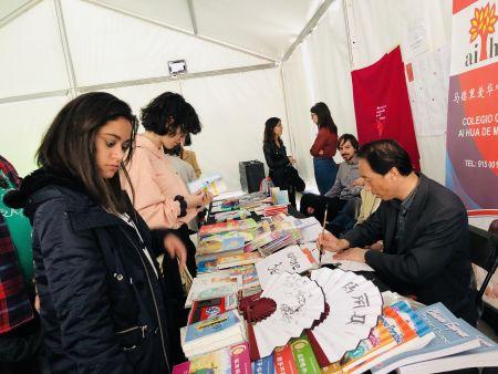 汉语爱好者驻足书摊(图片来源:西班牙《欧华报》) 汉语爱好者驻足书摊(图片来源:西班牙《欧华报》)