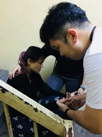 伤者黄晓曼（左）在峇都选区为希盟分派宣传单时，被不明物体掷中头部后昏倒，其他助选人员替她施救。（马来西亚《星洲日报》）