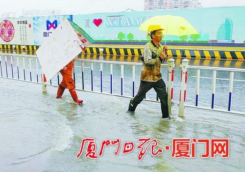 　昨日中午一位工人拿着工地挡板遮雨。(本报记者黄少毅 摄)