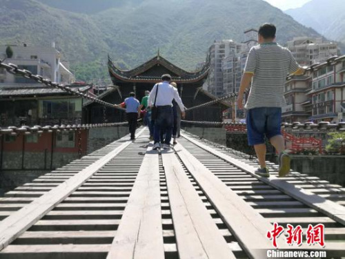 图为海外华文媒体代表走过泸定桥。　杨宗培 摄
