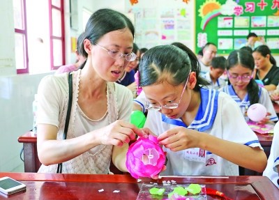 家长与学生互动，学习花灯制作技艺