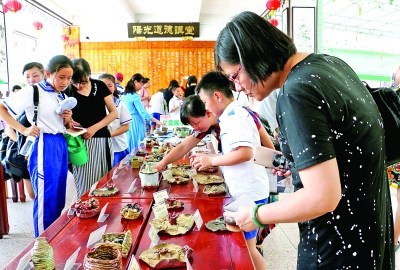 家长与学生选购义卖的陶艺作品 特约通讯员 王永平 摄影报道 家长与学生选购义卖的陶艺作品 特约通讯员 王永平 摄影报道