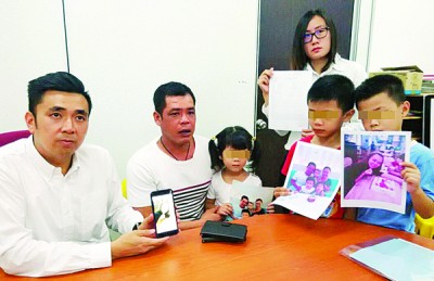 许罗全与3名稚龄子女盼望邓春美早日回家团聚。左为方美铼、右为王育璇。(图片来源:马来西亚光华网) 许罗全与3名稚龄子女盼望邓春美早日回家团聚。左为方美铼、右为王育璇。(图片来源:马来西亚光华网)