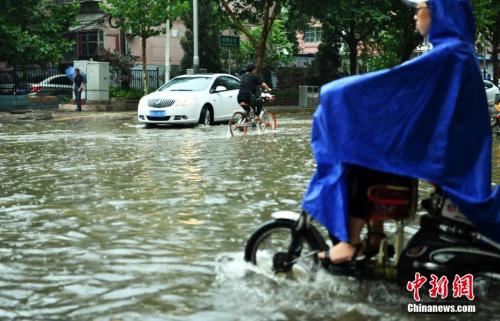 7月16日，河北石家庄一条马路积水严重，民众涉水骑行。当日，该省气象台发布暴雨蓝色预警，多地遭受暴雨袭击。<a target='_blank' href='http://www.chinanews.com/'>中新社</a>记者 翟羽佳 摄