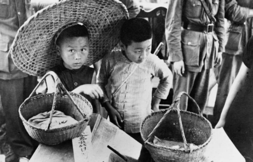  1938年7月7日，武汉民众开展抗日献金运动。这是卖白兰花的儿童把售花所得献给抗日运动。新华社发