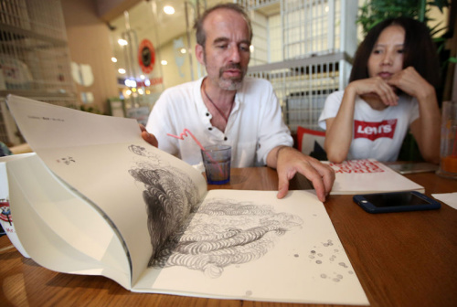 捷克艺术家伊瑞向记者展示其中国画作品集。 捷克艺术家伊瑞向记者展示其中国画作品集。