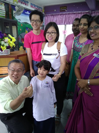 7岁的李烙暄成了罗白淡小唯一的华裔学生；前排左为周世扬；后排左起为李国闻夫妇；右1为校长玛娜海。（马来西亚《光华日报》）