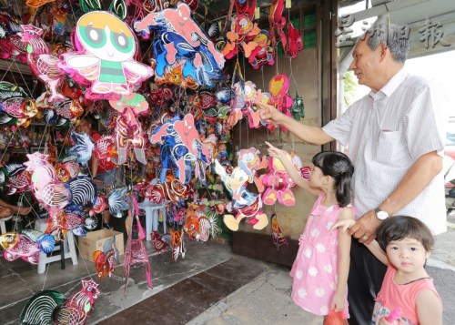 罗进锡每年中秋节，都会带着孙女到商店选购喜爱的灯笼。（马来西亚《星洲日报》）