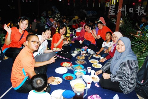 峇都基基启新华小的华裔教师及友族同事一起坐下来共享手抓饭。（马来西亚《星洲日报》）