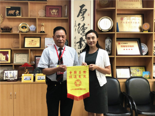 市侨联主席林春晖致送锦旗给美国广东侨胞联合总会主席赵镜源。