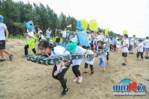 市民和游客体验潭门赶海运动会合力过杆活动。 李心如 摄 市民和游客体验潭门赶海运动会合力过杆活动。 李心如 摄