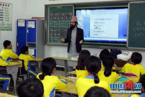 海南师大尼泊尔籍学生给小学生介绍课堂情况。　黄敏 摄