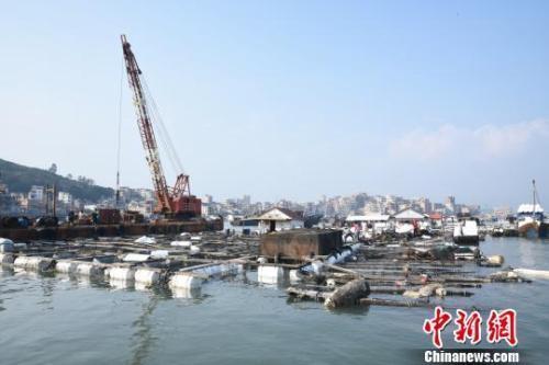 在受碳九泄漏影响的泉州市泉港区肖厝码头,起吊船对受损渔排进行加固。陈龙山 摄 在受碳九泄漏影响的泉州市泉港区肖厝码头,起吊船对受损渔排进行加固。陈龙山 摄