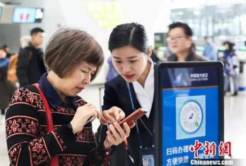 地服人员指引旅客使用电子化服务 南宣 摄