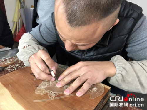 皮影匠人用华州皮影独一无二的“推皮走刀法”雕刻。摄影:张捷 皮影匠人用华州皮影独一无二的“推皮走刀法”雕刻。摄影:张捷