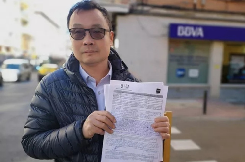 侨胞Enguan Chen在Usera一家BBVA营业厅门前向媒体展示了他的投诉单。(图片来源:《国家报》) 侨胞Enguan Chen在Usera一家BBVA营业厅门前向媒体展示了他的投诉单。(图片来源:《国家报》)