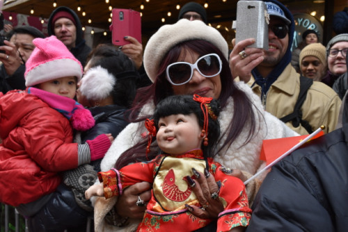 纽约曼哈顿华埠举办新春大游行，Olga Benitez特意带着心爱的娃娃挤在人群中一起观看游行。(美国《世界日报》/颜嘉莹 摄)
