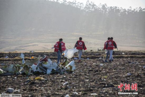 图为救援人员在坠机现场清理飞机残骸。