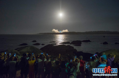 “长征七号”运载火箭在海南文昌航天发射场点火升空，民众纷纷举起手机拍摄。骆云飞 摄