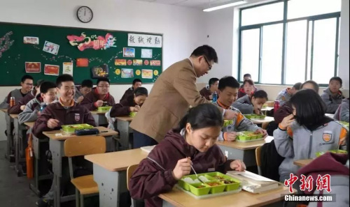 南京钟英中学的校长走进教室与学生一起吃中饭。葛勇 摄