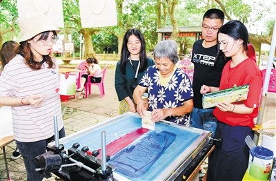 嘉年华活动设计和丝印组成员手把手教村民制作丝印作品。 海南日报记者 苏晓杰 通讯员 王家专 摄