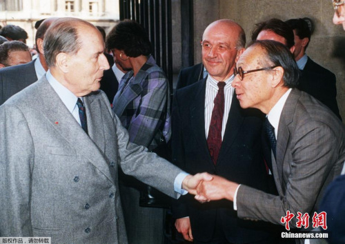 图为1989年3月29日，法国前总统密特朗(左)在出席巴黎卢浮宫金字塔开幕式时与贝聿铭(右)握手。