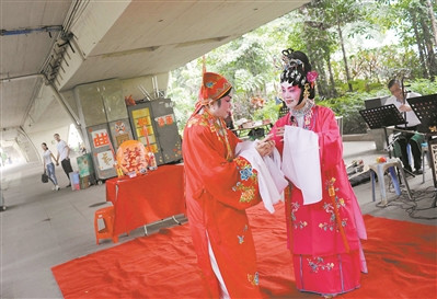 广州沙面的引桥下成了大戏台，每周四大戏准时上演，这是正在演出的莲姐与玉姐的折子戏。