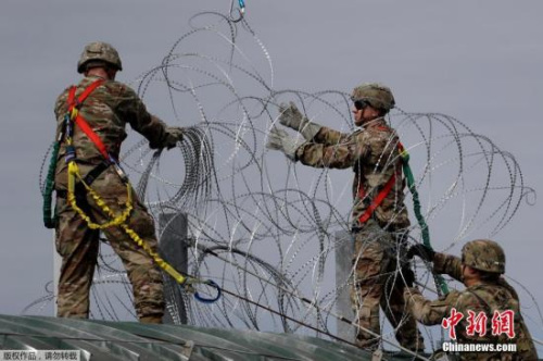 资料图：中美洲移民大军压境美国，美国士兵在美墨边境安装铁丝网严防移民入境。
