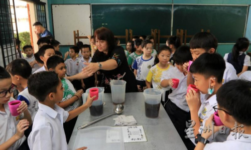 清热凉茶以蜜糖或黄糖调味，学生们喝得津津有味。(马来西亚《星洲日报》/李祝福 摄)