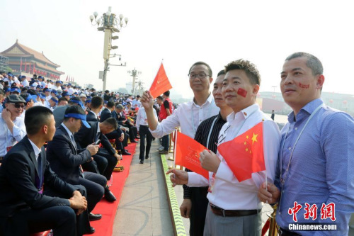 10月1日，庆祝中华人民共和国成立70周年大会在北京隆重举行。约2000名海外华侨华人在现场见证了历史时刻。他们表示，国庆庆典展现了中华民族的自信和威严，凝聚起了全球侨胞的心。图为来自巴布亚新几内亚的薛辉雄等在观礼台合影。<a target='_blank' href='http://www.chinanews.com/'>中新社</a>记者 任海霞 摄