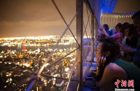 在纽约帝国大厦上观赏夜景的女性。<a target='_blank' href='http://www.chinanews.com/'>中新社</a>记者 廖攀 摄