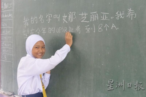 娜芝丽亚以工整的中文字体,在黑板上写下自己的心愿。(来源:星洲日报) 娜芝丽亚以工整的中文字体,在黑板上写下自己的心愿。(来源:星洲日报)