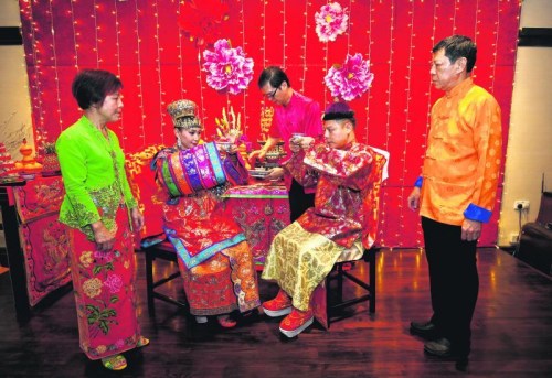 新郎的父亲李荣佳(右一)在给儿子操办婚礼时,特地前往马六甲重金礼聘传统婚礼礼仪师,而部分古董和珠宝是来自他个人及友人的收藏。多方奔走后,最终圆满举行了一场遵循传统习俗的婚礼。 (新加坡《联合早报》/梁麒麟 摄) 新郎的父亲李荣佳(右一)在给儿子操办婚礼时,特地前往马六甲重金礼聘传统婚礼礼仪师,而部分古董和珠宝是来自他个人及友人的收藏。多方奔走后,最终圆满举行了一场遵循传统习俗的婚礼。 (新加坡《联合早报》/梁麒麟 摄)