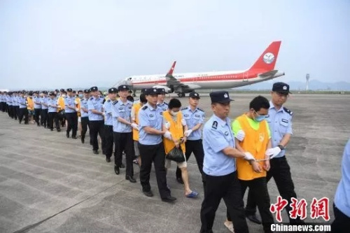 资料图:警察在押回“杀猪盘”诈骗人员。(图源:中国新闻网) 资料图:警察在押回“杀猪盘”诈骗人员。(图源:中国新闻网)