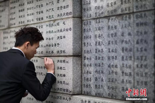 2019年11月18日，南京审计大学的志愿者为侵华日军南京大屠杀遇难者名单墙(又称“哭墙”)上的遇难者名字逐一“描新”，寄托哀思。<a target='_blank' href='http://www.chinanews.com/'>中新社</a>记者 泱波 摄