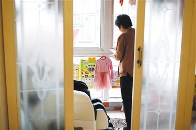 12月23日,天津滨海新区,好友要给张英2岁的女儿买新衣服,汤玉娥拍照给好友看现有的衣服样式。 12月23日,天津滨海新区,好友要给张英2岁的女儿买新衣服,汤玉娥拍照给好友看现有的衣服样式。