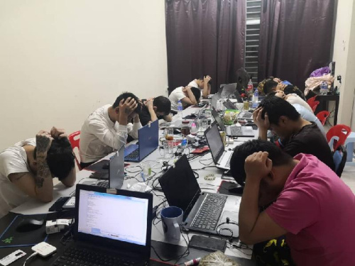 涉及非法网络赌博活动的中国籍男子被捕后，低头坐在电脑前。(马来西亚《星洲日报》)