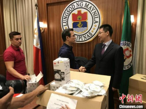 　1月14日，中国驻菲律宾大使馆向菲律宾首都马尼拉市赠送千枚N95口罩，用于火山喷发后的防护，马尼拉市长莫仁诺（左）亲自接收。中国驻菲使馆供图
