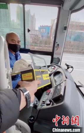 太原海归青年刘文奇将自己在网上购买的口罩送给公交车司机。受访者供图