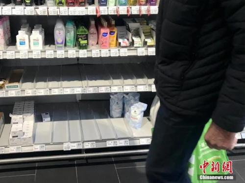 当地时间3月12日，德国柏林市中心一家大型超市，一名顾客经过被抢购一空的消毒液和洗手液货架。<a target='_blank' href='http://www.chinanews.com/'>中新社</a>记者 彭大伟 摄